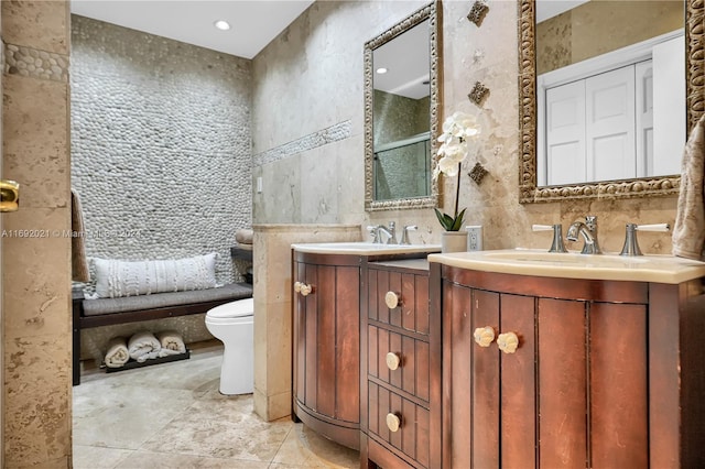 bathroom with tile walls, vanity, tile patterned floors, and toilet