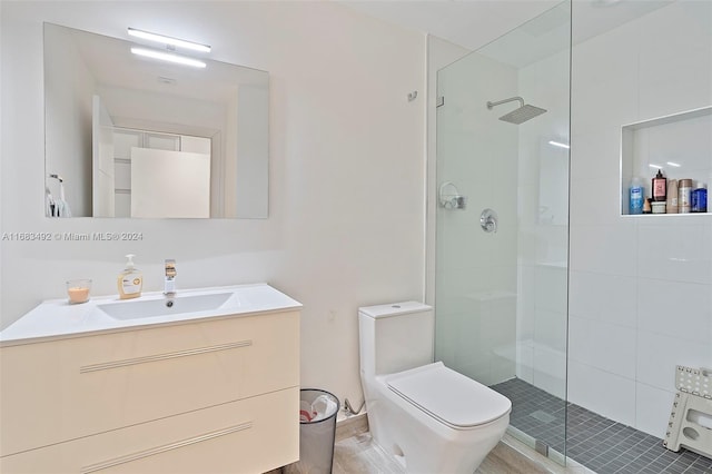 bathroom featuring vanity, toilet, and tiled shower