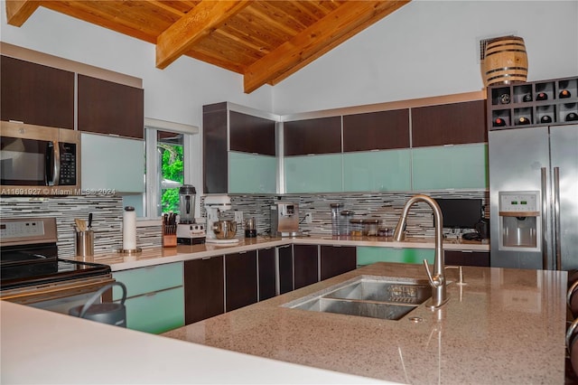 kitchen with stainless steel appliances, vaulted ceiling with beams, wood ceiling, sink, and dark brown cabinets