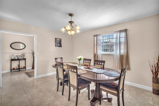 dining area with a textured ceiling and a notable chandelier