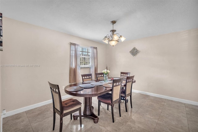 dining area featuring a textured ceiling and a notable chandelier