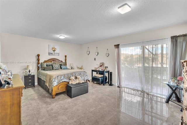 tiled bedroom featuring a textured ceiling and access to exterior