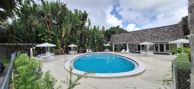 view of swimming pool with a patio and french doors