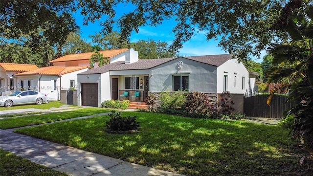 view of front of home featuring a porch, a front yard, and a garage