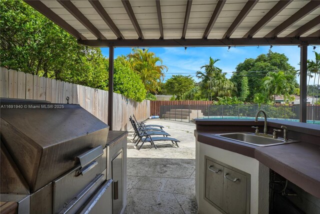 view of patio / terrace with an outdoor kitchen and sink