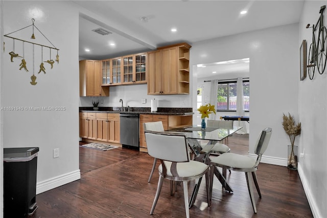 kitchen featuring sink, dark hardwood / wood-style floors, stainless steel dishwasher, and dark stone counters