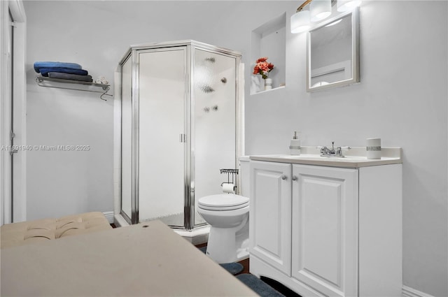 bathroom featuring vanity, an enclosed shower, and toilet