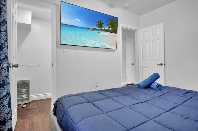 bedroom featuring dark hardwood / wood-style flooring and heating unit