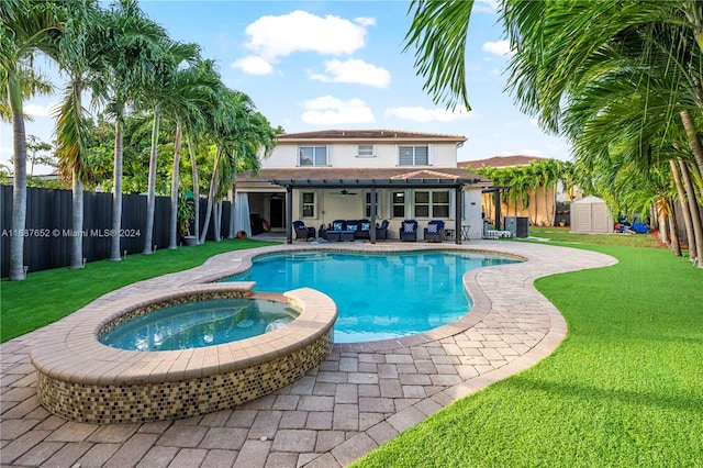 view of pool with an outdoor hangout area, an in ground hot tub, a shed, a lawn, and ceiling fan