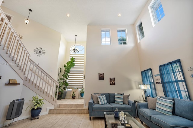 tiled living room featuring a high ceiling and a chandelier