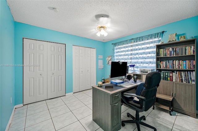 office space featuring a textured ceiling, ceiling fan, and light tile patterned floors