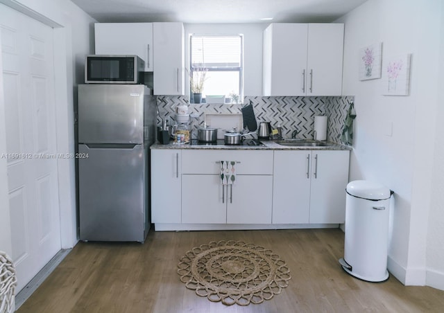 kitchen featuring white cabinetry, appliances with stainless steel finishes, and backsplash