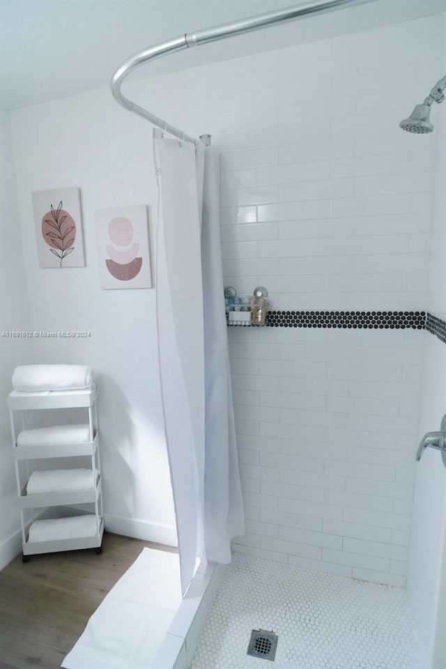 bathroom with wood-type flooring and curtained shower