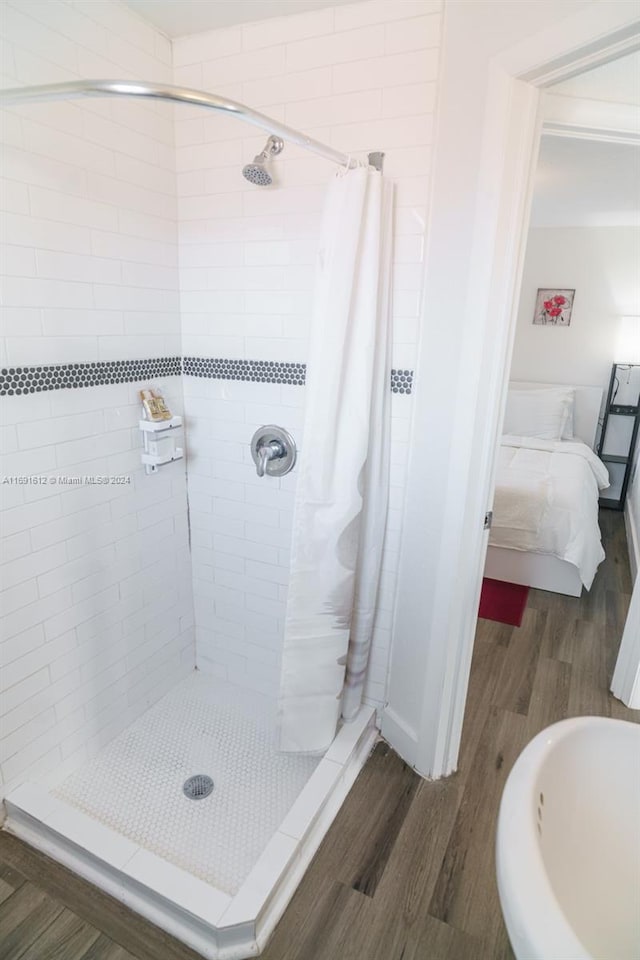 bathroom with a shower with curtain and hardwood / wood-style flooring