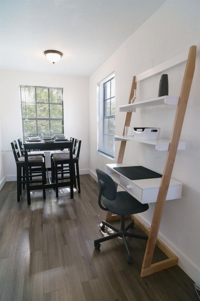 office with a healthy amount of sunlight and dark hardwood / wood-style floors