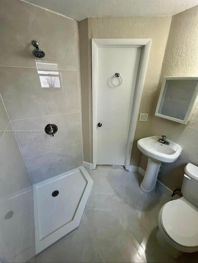 bathroom with tiled shower and toilet