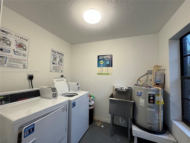 washroom with water heater, a textured ceiling, sink, and independent washer and dryer