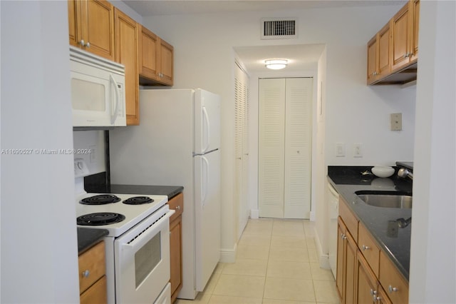 kitchen featuring white appliances, sink, and light tile patterned flooring