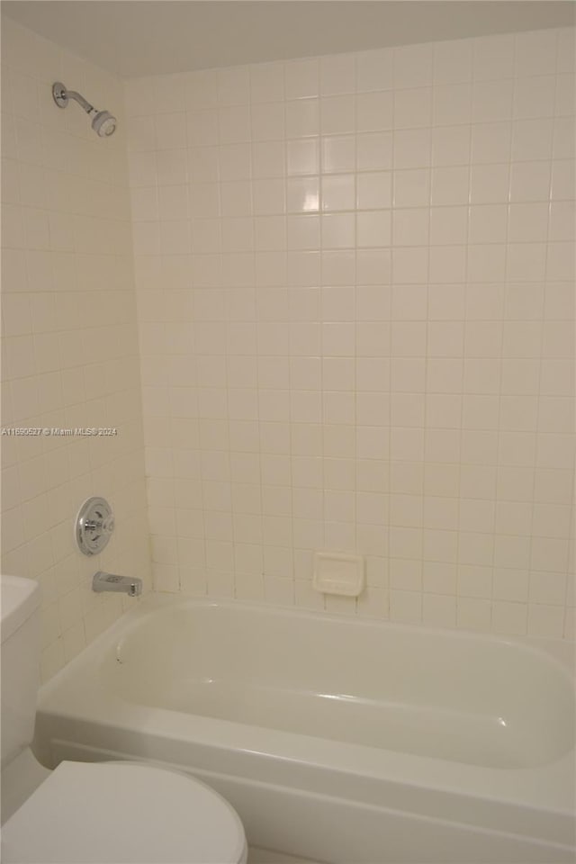 bathroom featuring toilet and tiled shower / bath combo