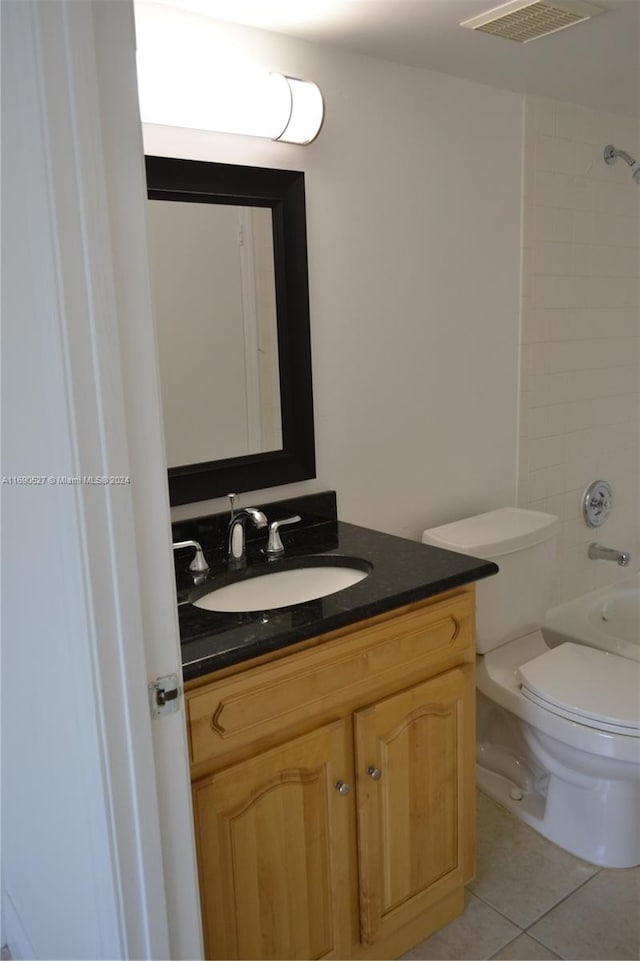 full bathroom with toilet, vanity, tiled shower / bath combo, and tile patterned floors