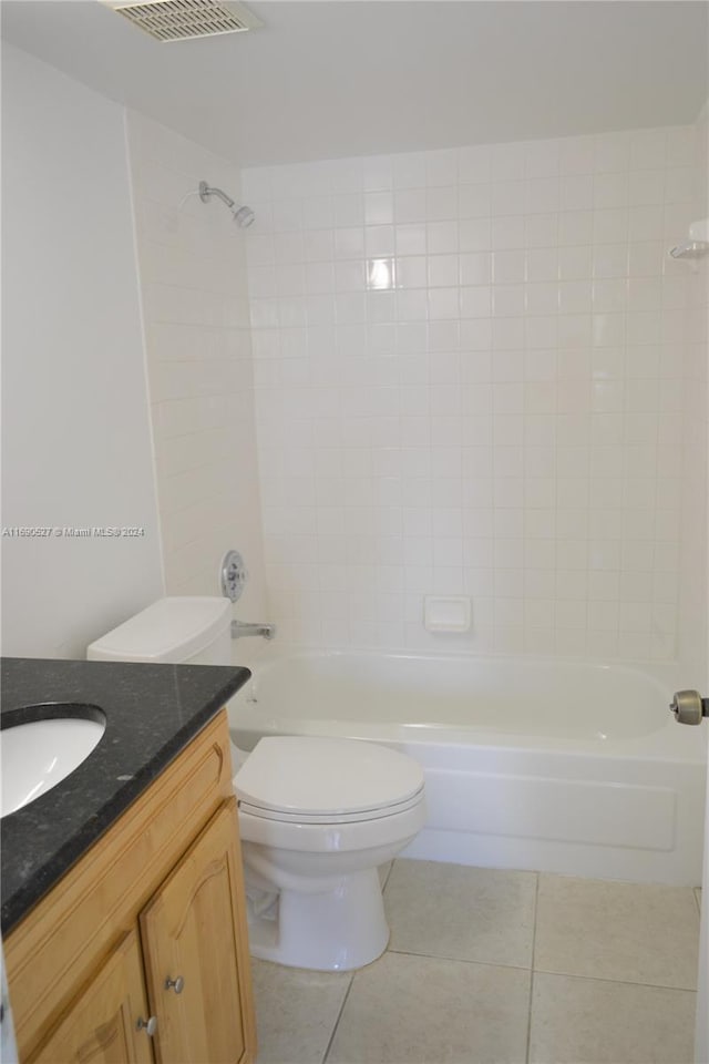 full bathroom featuring toilet, vanity, tiled shower / bath, and tile patterned flooring