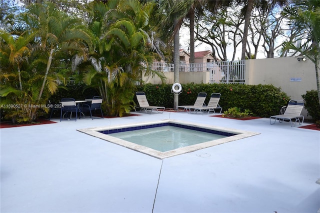 view of swimming pool featuring a community hot tub and a patio area