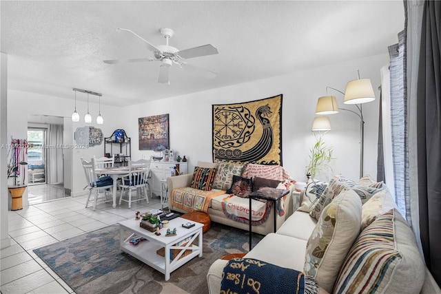 living room with a textured ceiling, ceiling fan, and light tile patterned flooring