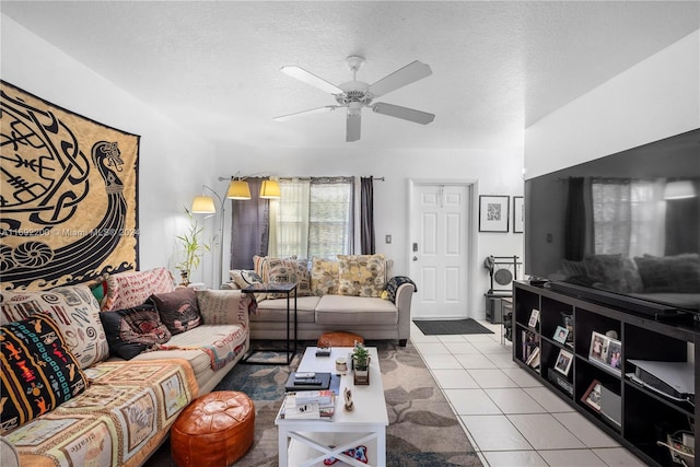 living room featuring light tile patterned flooring, ceiling fan, and a textured ceiling