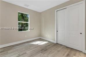 unfurnished bedroom with light hardwood / wood-style floors and a closet