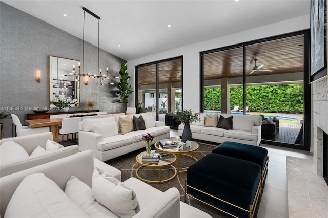 living room featuring ceiling fan with notable chandelier and high vaulted ceiling