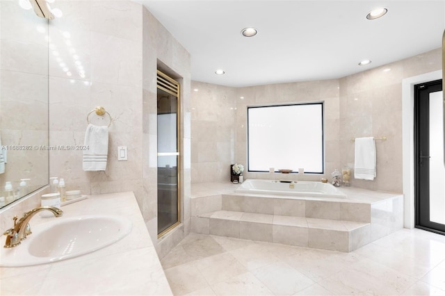 bathroom featuring tile walls, vanity, and separate shower and tub