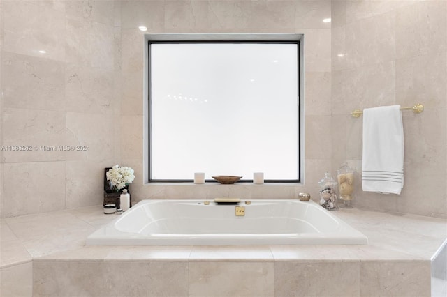 bathroom featuring tile walls and tiled bath