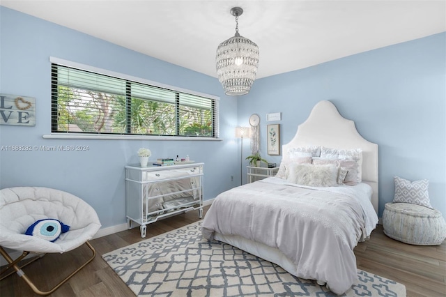 bedroom featuring dark hardwood / wood-style flooring and a chandelier