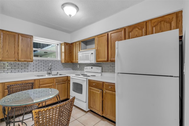 kitchen featuring backsplash, a textured ceiling, light tile patterned floors, sink, and white appliances