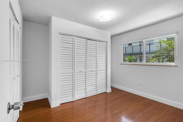 unfurnished bedroom featuring hardwood / wood-style floors and a textured ceiling