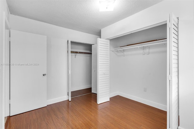 unfurnished bedroom with wood-type flooring and a textured ceiling