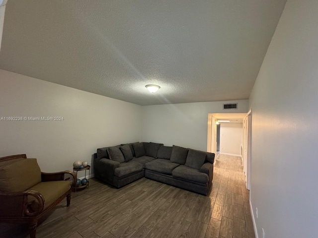 living room with a textured ceiling and hardwood / wood-style flooring