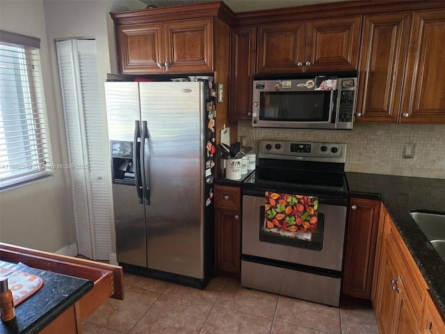 kitchen featuring tasteful backsplash, plenty of natural light, stainless steel appliances, and dark stone counters