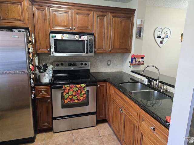 kitchen with a sink, tasteful backsplash, stainless steel appliances, and brown cabinets