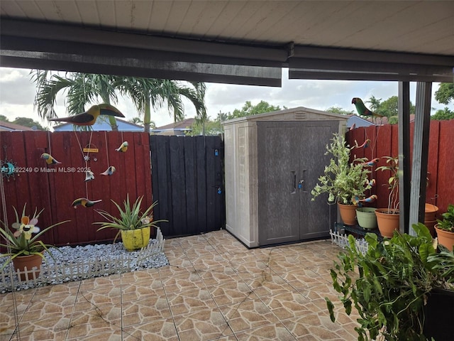 view of patio / terrace featuring a storage shed, fence, and an outdoor structure