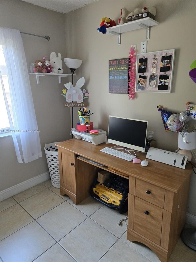 office space featuring baseboards and light tile patterned flooring