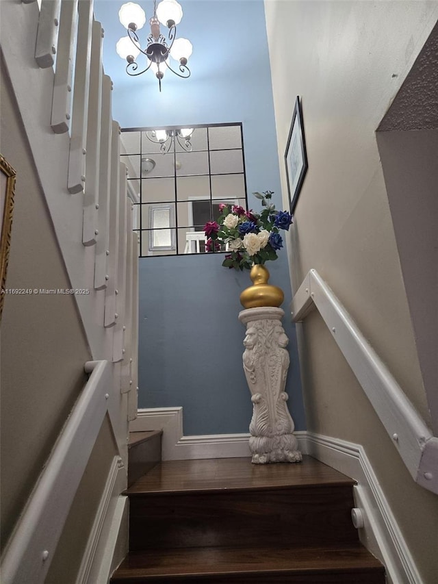 stairway featuring a notable chandelier and hardwood / wood-style flooring