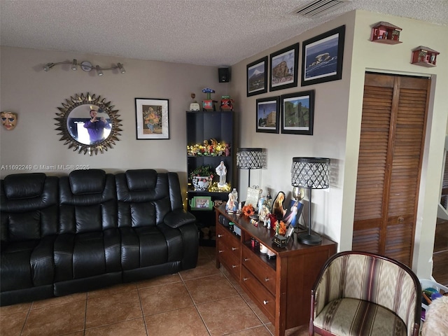 tiled living room featuring a textured ceiling