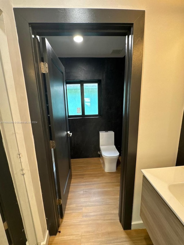 bathroom with vanity, wood-type flooring, and toilet