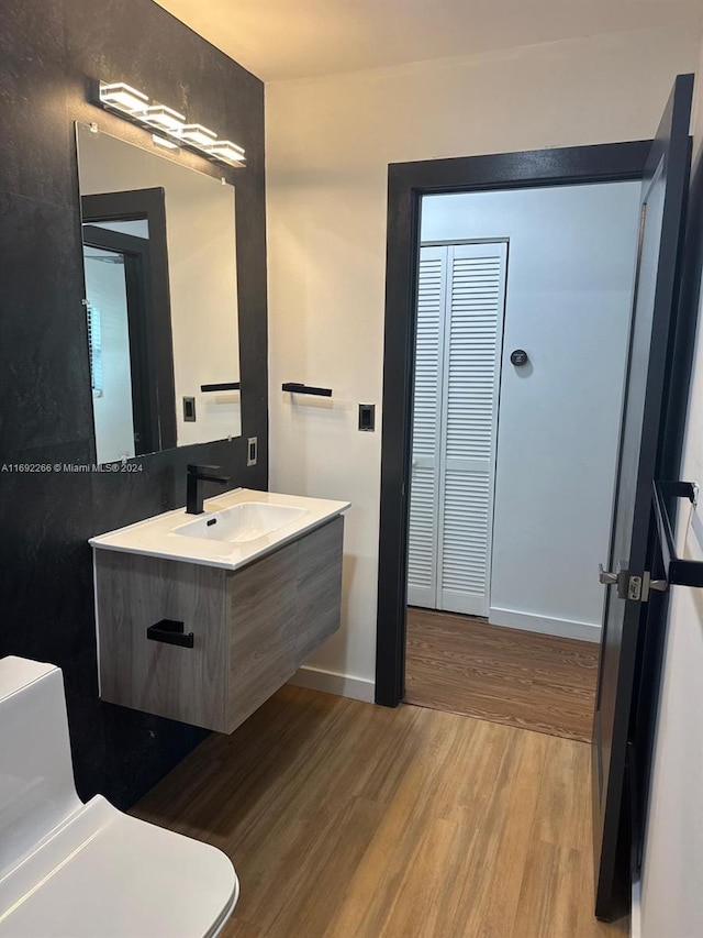 bathroom with vanity, toilet, and wood-type flooring