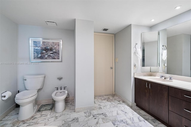 bathroom featuring toilet, vanity, and a bidet