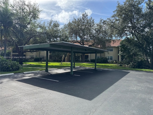 view of parking with a lawn and a carport