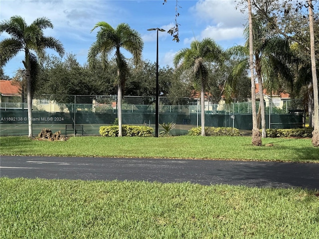 view of sport court featuring a lawn