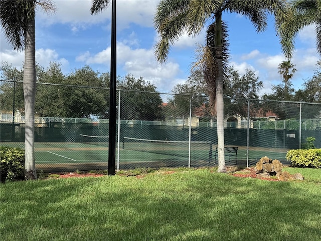 view of tennis court with a lawn