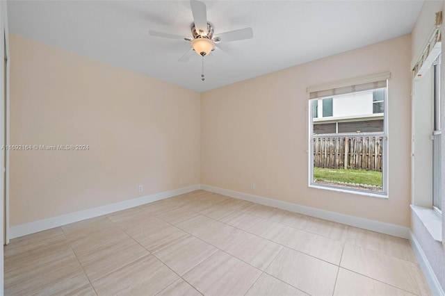 spare room featuring light tile patterned flooring, ceiling fan, and plenty of natural light